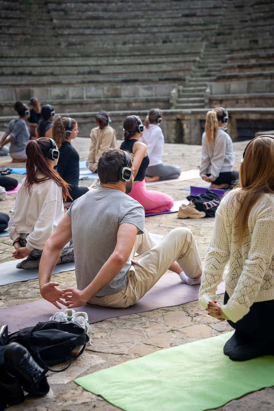 Una clase de yoga con auriculares AURA al aire libre