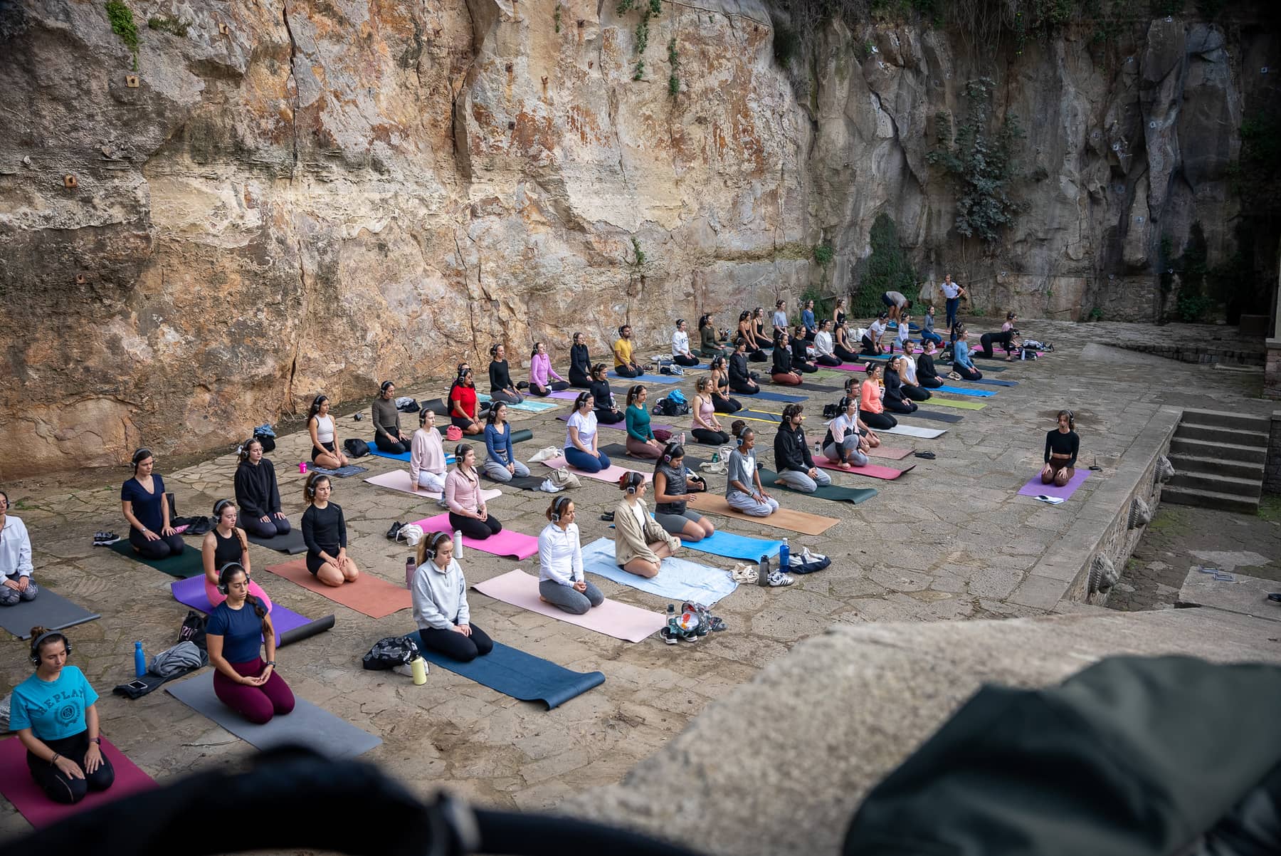 Personas meditando con auriculares AURA en una cantera de piedra de Barcelona